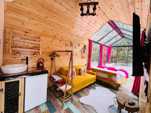 a log cabin with a yellow couch and a bed at Eça River Bungalov in Ayder Yaylasi