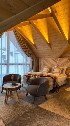 a bedroom with a bed and a chair and a table at Nova Hill in Zakopane