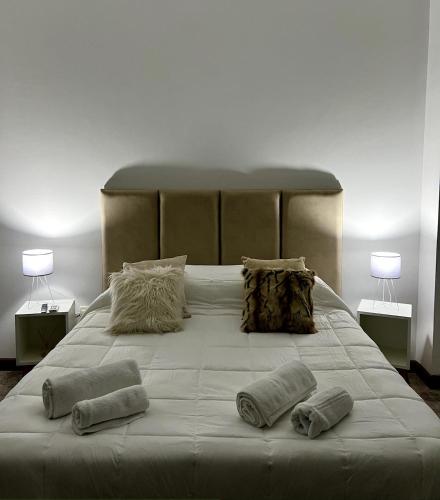 a large white bed with three pillows on it at Welindo Loft in Salta