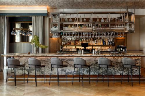 a bar with gray stools in a room at Kimpton La Peer West Hollywood by IHG in Los Angeles
