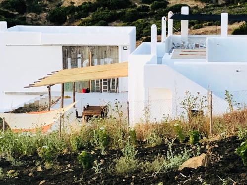 a white house with a hammock in front of it at Dar-west in Demina