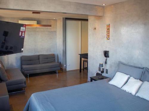a bedroom with a blue bed and a couch at Cobertura vista mar in Natal