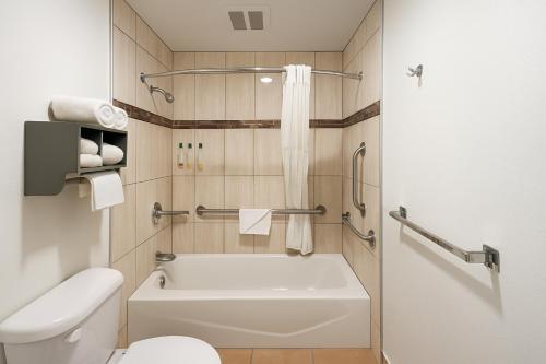 un bagno con una vasca bianca e un water di El Castell Motel a Monterey