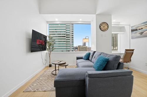 a living room with a couch and a clock on a wall at Luxury 1Beds and 2Beds in Downtown Edmonton close to Rogers in Edmonton
