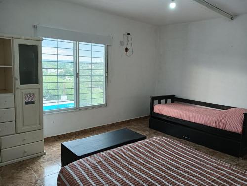 a bedroom with a bed and a dresser and a window at Los Talitas in Villa Parque Siquiman