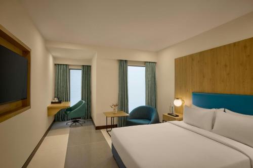 a hotel room with a bed and a tv at The Fern Residency Ahmedabad, Subhash Bridge, Series by Marriott in Ahmedabad
