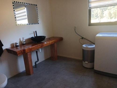 a bathroom with a wooden sink and a mirror at Casa Entre Cerros in Futrono