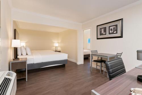 a hotel room with a bed and a desk at El Castell Motel in Monterey