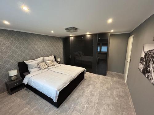 a bedroom with a large bed and a bathroom at Perfect for longer stays in Heinsberg
