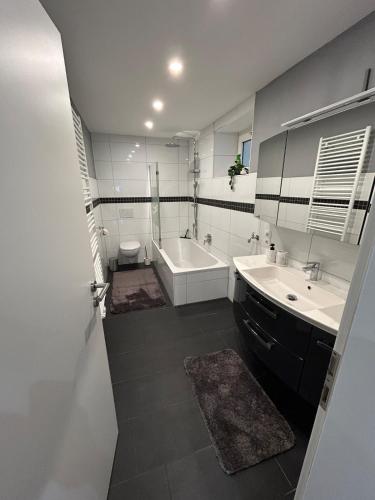 a bathroom with a tub and a toilet and a sink at Perfect for longer stays in Heinsberg