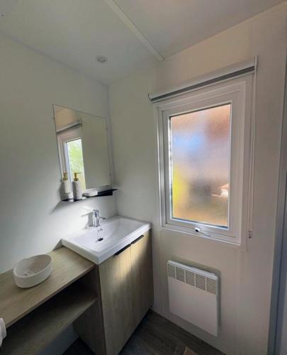 a bathroom with a sink and a window at Bienvenue au Cap Ferret in Lège-Cap-Ferret