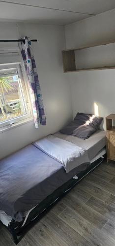 a bed in a bedroom with a window at Bienvenue au Cap Ferret in Lège-Cap-Ferret