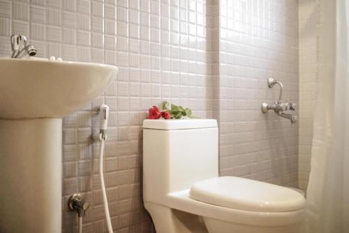 a bathroom with a toilet and a sink at Royal Serenity - Kammanahalli in Bengaluru