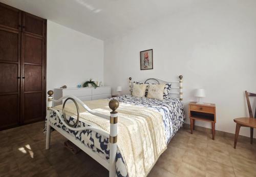 a white bedroom with a bed and a table at Casa Prainha da Luz in Luz