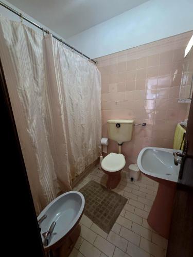 a bathroom with a toilet and a bidet and a sink at Casa Prainha da Luz in Luz