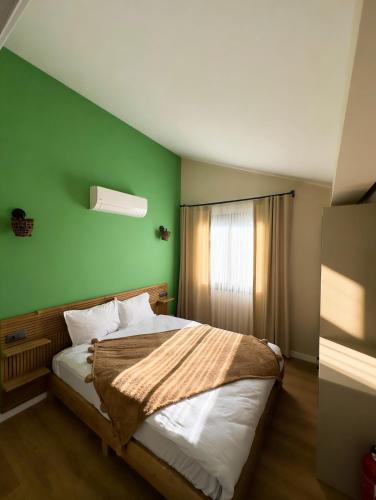 a bedroom with a bed with a green wall at InOut Social in Fethiye