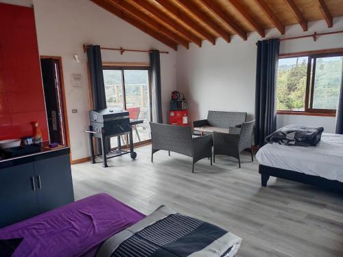 a room with a bedroom with a bed and a desk at Cabañas Mirador de Maitencillo 2 in Maitencillo