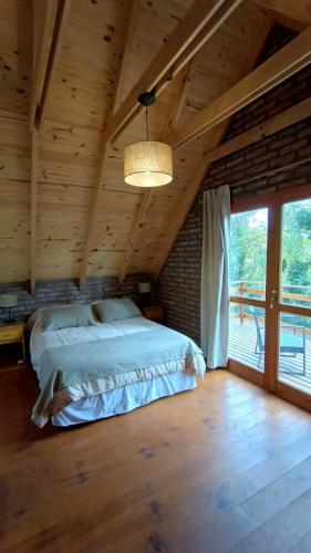 a bedroom with a large bed in a wooden room at La Rubina in Villa Ventana