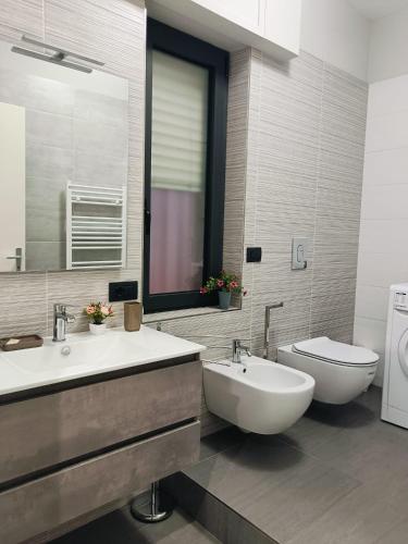 a bathroom with two sinks and a toilet at CASA DIDYMA in San Giovanni Gemini