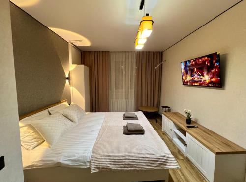 a bedroom with a bed and a tv on the wall at Chișinău Airport Comfort in Chişinău
