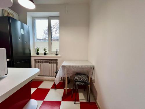 a kitchen with a table and a red and white floor at Chișinău Airport Comfort in Chişinău