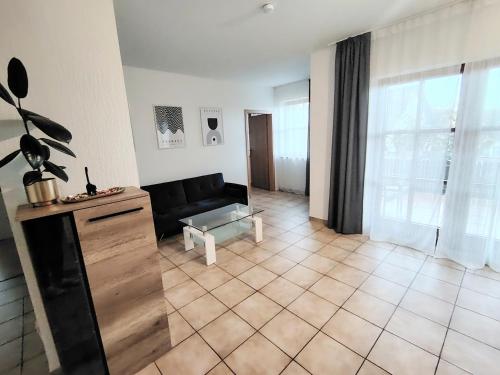 a living room with a black couch and a table at Gemütliche 100 qm Wohnung mit Balkon in Wernsdorf