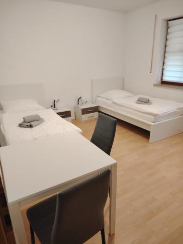 a room with two beds and a table and chairs at Gemütliche 100 qm Wohnung mit Balkon in Wernsdorf