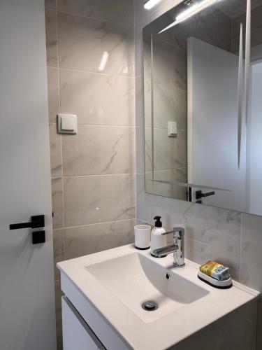a white bathroom with a sink and a mirror at Casa Ventura in Lagos