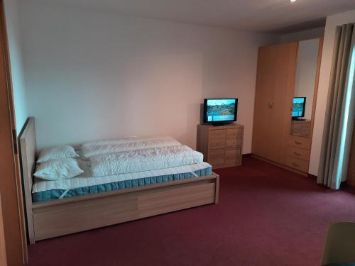 a bedroom with a bed and a flat screen tv at Apartment Lyso en Soly in Königsleiten
