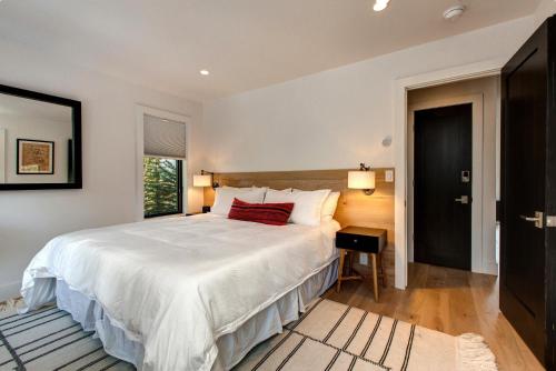a bedroom with a large white bed and a window at Abode at Rendezvous in Teton Village