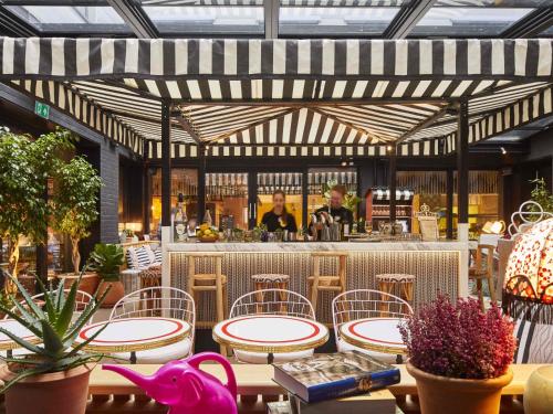 een restaurant met tafels en stoelen en een bar bij Mama Shelter London - Shoreditch in Londen