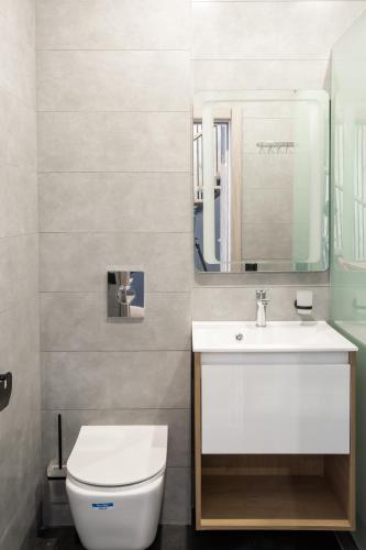 a bathroom with a white toilet and a sink at Apex Panorama Hotel in Yablunytsya