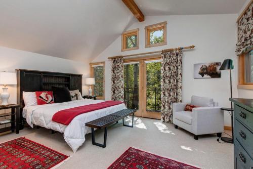 a bedroom with a bed and a chair and windows at Abode at Moose Creek #21 in Teton Village