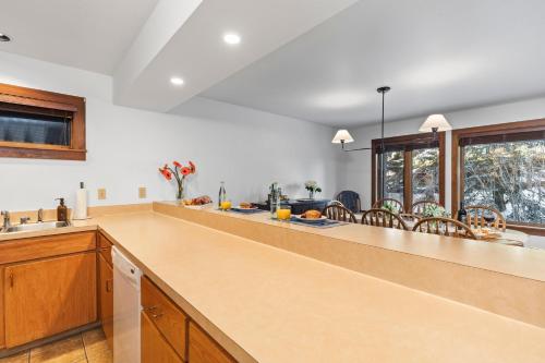 a large kitchen with a large counter top and windows at Abode at Sundance in Teton Village