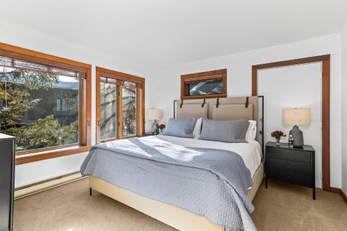 a bedroom with a bed and two windows at Abode at Sundance in Teton Village