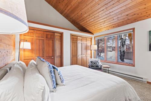 a bedroom with a white bed and a wooden ceiling at Abode at Fish Creek in Wilson