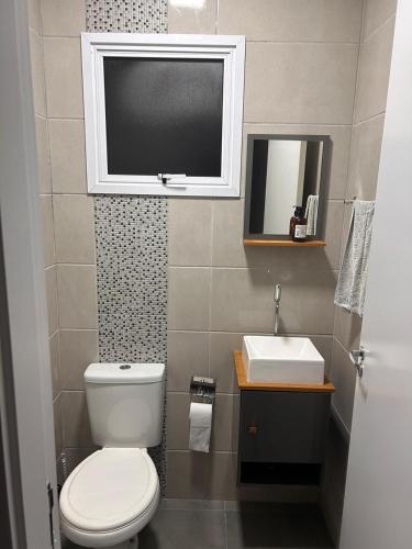 a small bathroom with a toilet and a sink at Casa com três quartos, piscina e área Gourmet in Torres