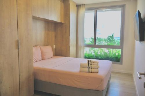 a small bedroom with a bed with a window at Lujoso Departamento con Garage in Caña de Castilla