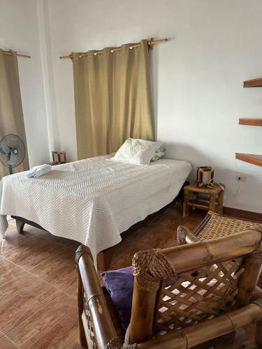 a bedroom with a bed and a chair in it at Casa Vichayito - Los Órganos in Los Órganos