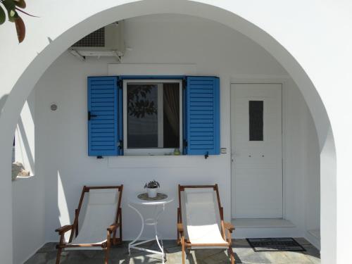 two chairs and a table in a room with a window at Gaia house, Ios Greece in Tzamaria