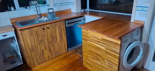 a kitchen with a sink and a washing machine at Spacious big sea views star bath in Paihia