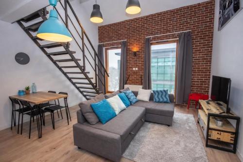 a living room with a couch and a brick wall at InPoint Smart Apartments in Krakow