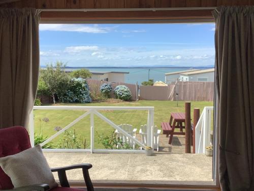 a view of the ocean from a patio door at Ocean Breeze Holiday Home in Riverton