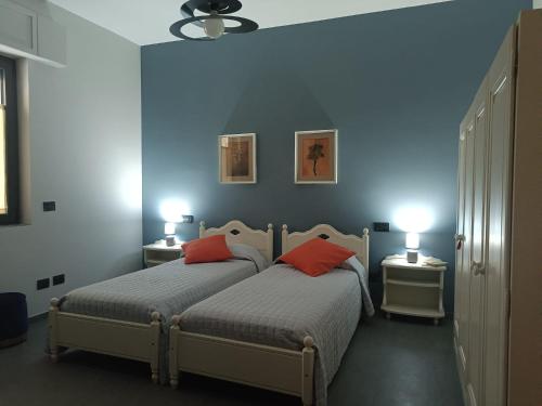 two beds in a bedroom with blue walls at CASA DIDYMA in San Giovanni Gemini