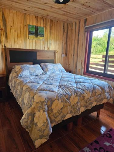 a bedroom with a bed in a wooden room at Las Victorias in Salto del Laja