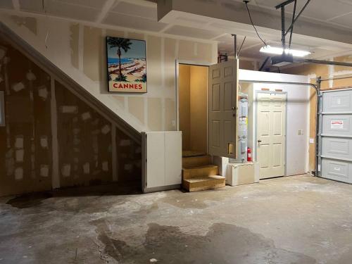 a garage with a staircase and an open refrigerator at Montgomery Apartment in Redding