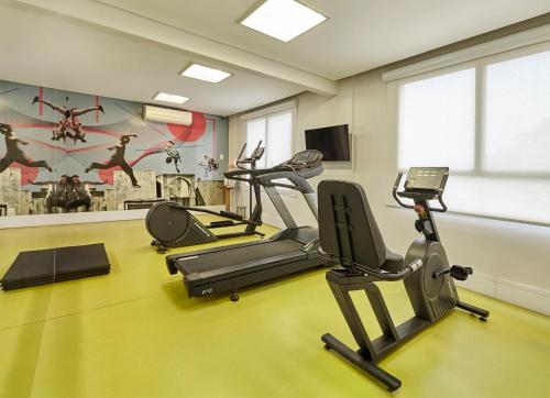 a gym with three treadmills and cardio machines at Nacional Inn Palmas in Palmas