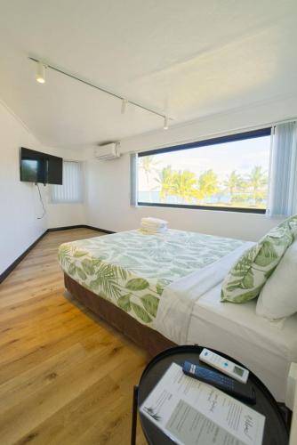 a bedroom with a large bed and a window at Lagoon Apartments in Nuku‘alofa