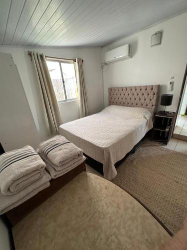 a small bedroom with two beds and a window at Moramay 2 in Punta del Este