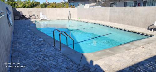 a swimming pool with blue water in front of a building at University Inn at San Luis Obispo in San Luis Obispo